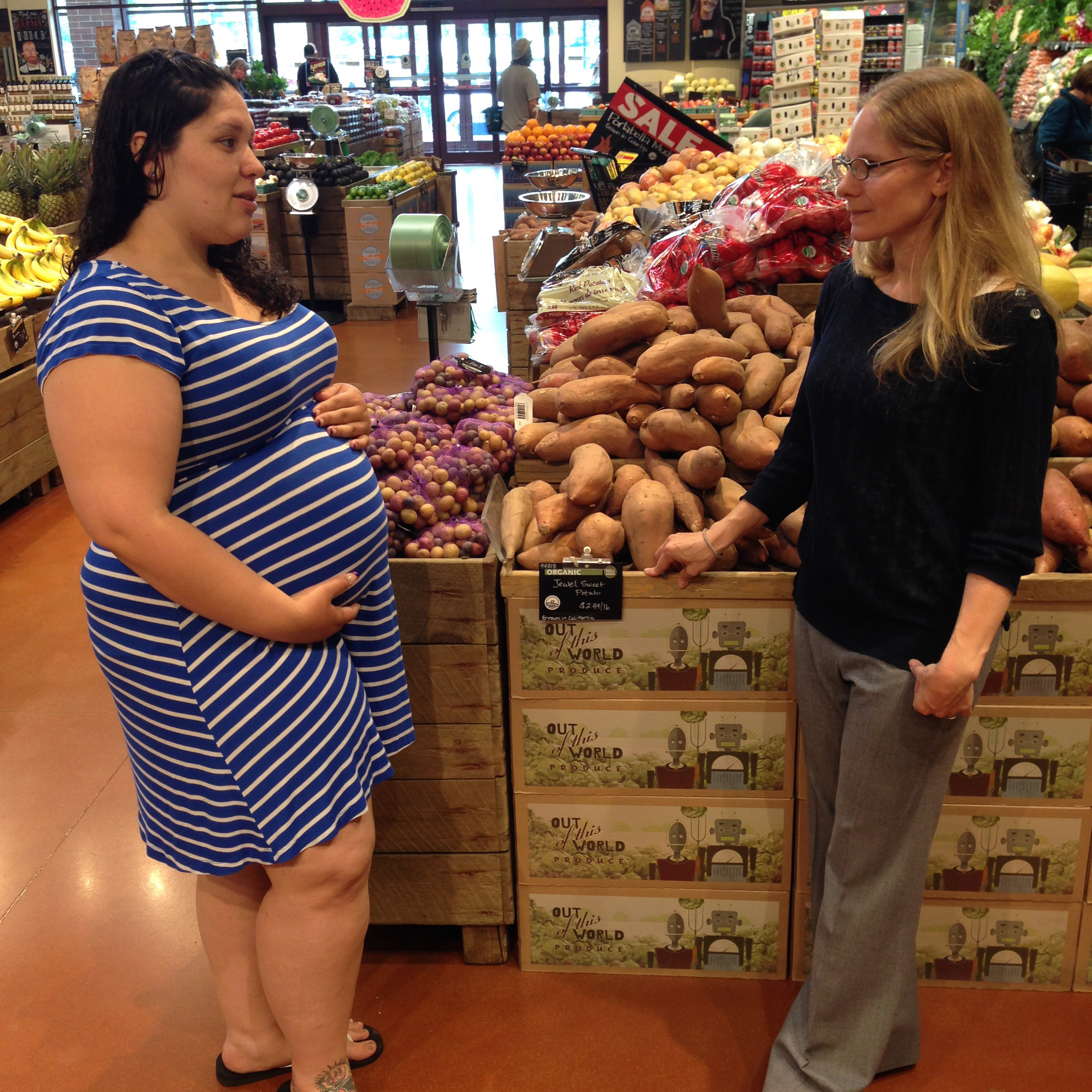 Photo of Curl and Lopez (pregnant) speaking in grocery store