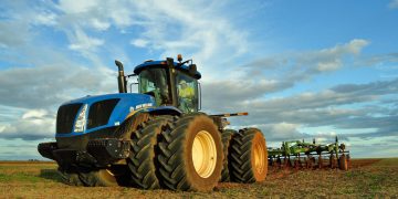 tractor em campo agrícola com céu azul
